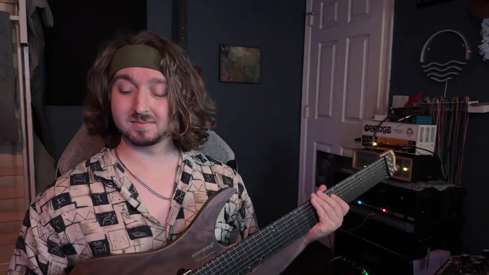 Jacob in the studio with a guitar, eyes closed, listening